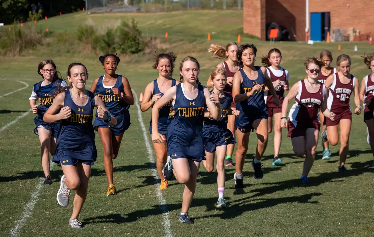 Group of Middle School female students running on athletics track