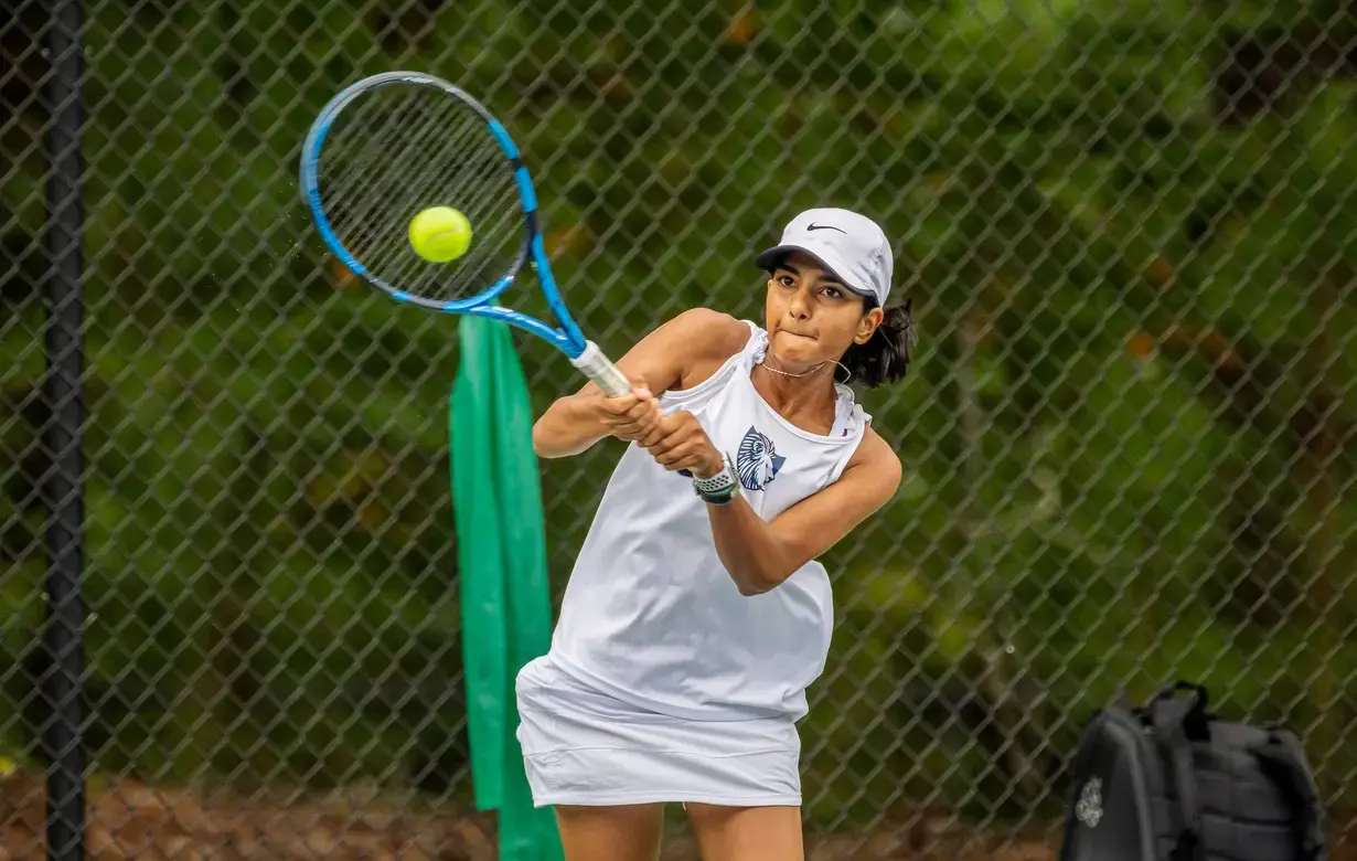 Female student playing tennis