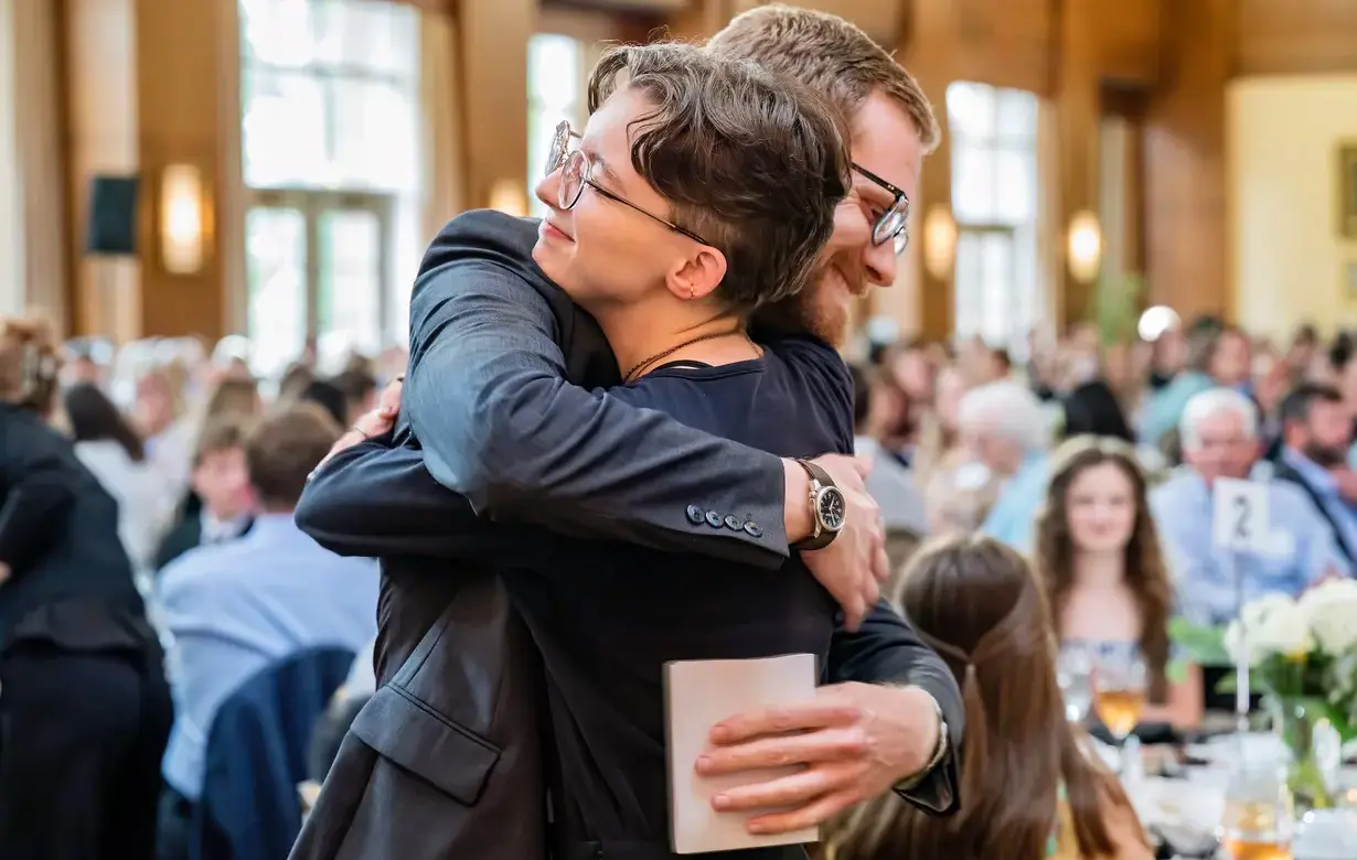 Faculty member embracing student at ceremony