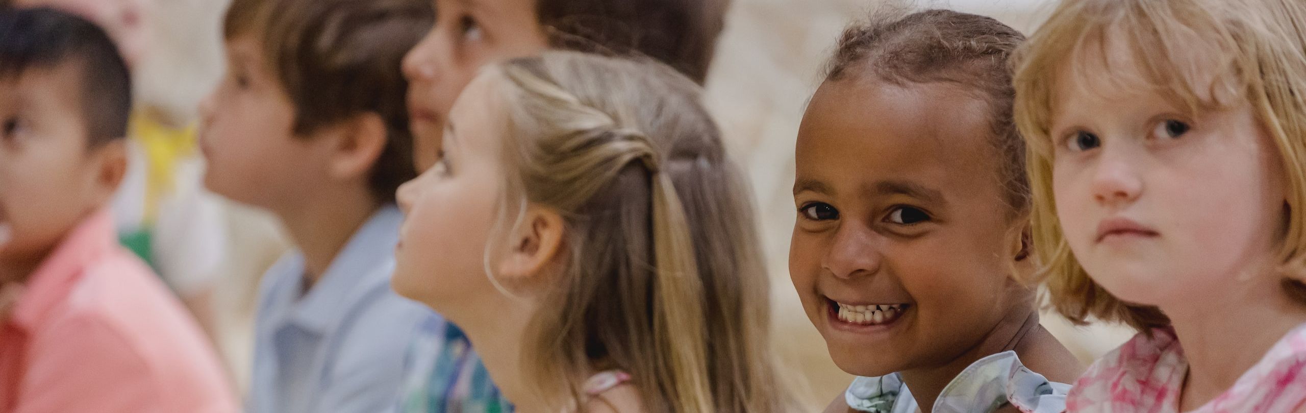 Lower school female student smiling surrounded by other happy students