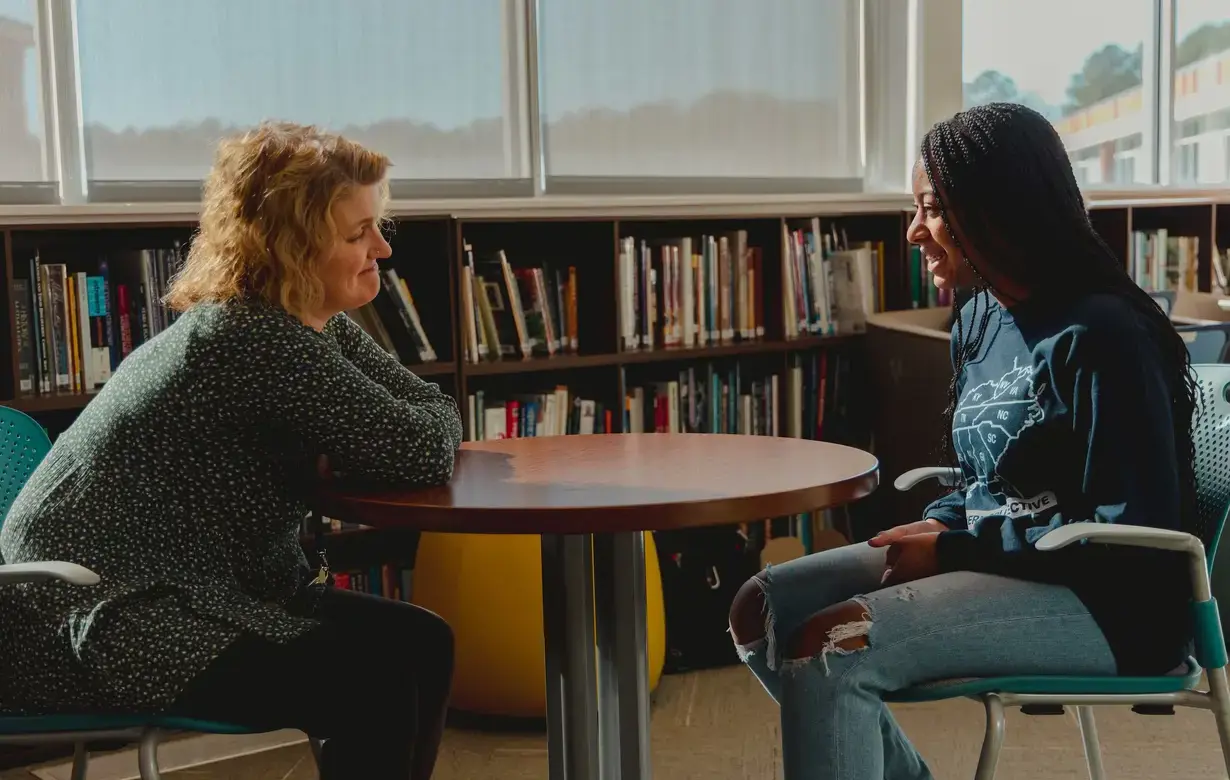 A smiling teacher engaging with a female student.