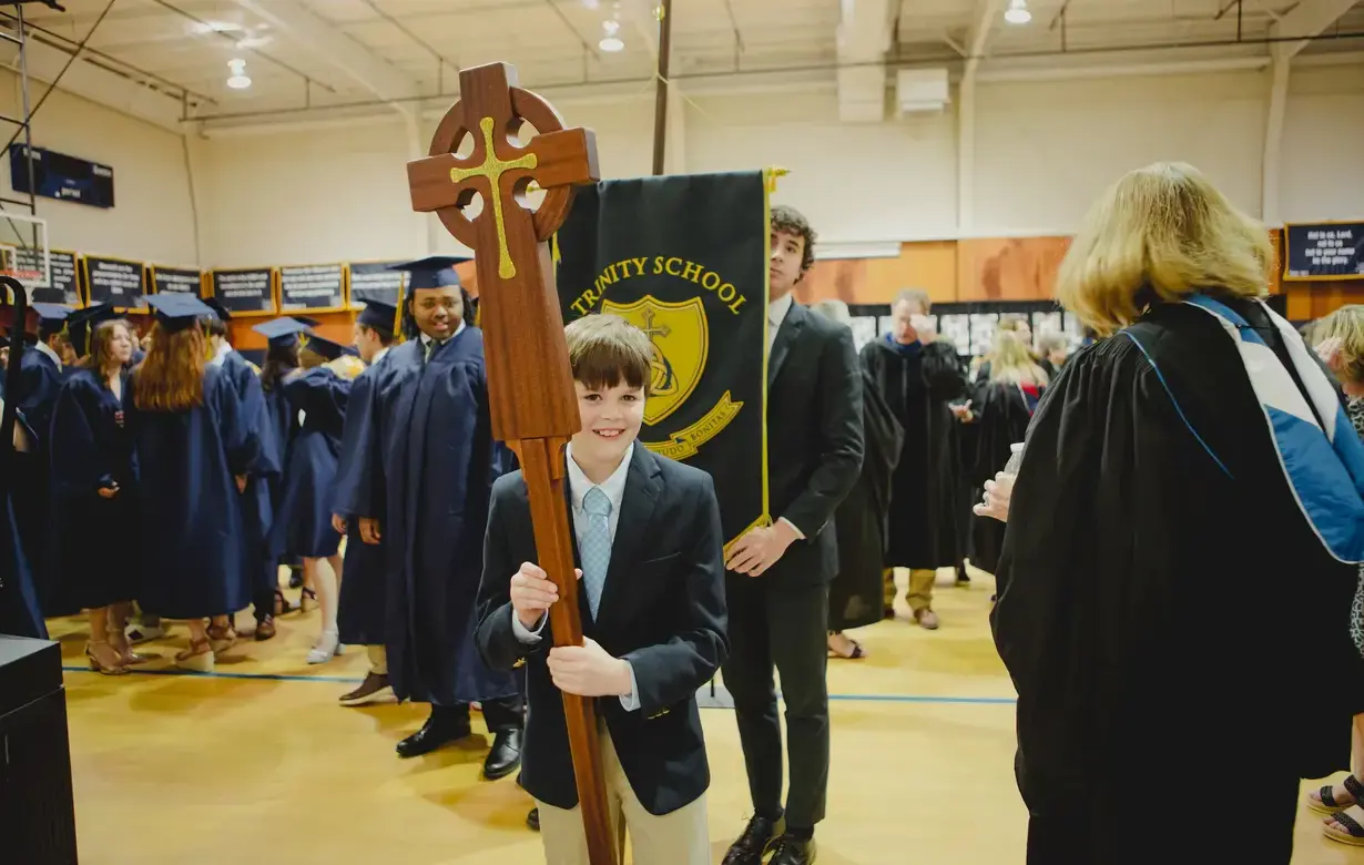 Young boy holding cross in procession